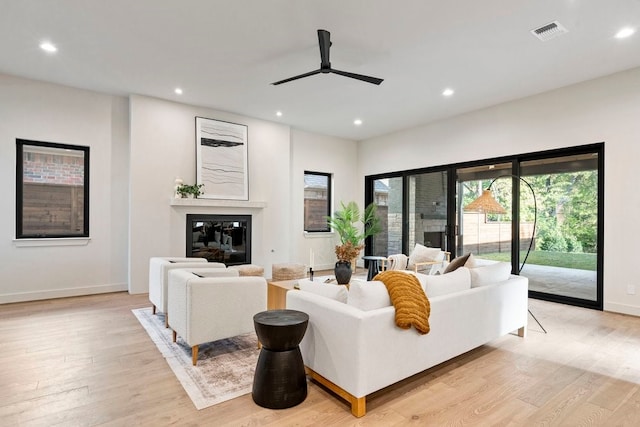 living room with ceiling fan and light hardwood / wood-style flooring