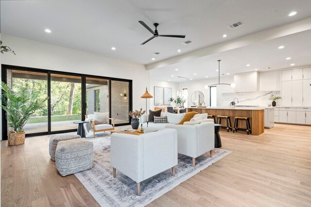 living room with ceiling fan and light wood-type flooring