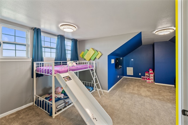 carpeted bedroom with a textured ceiling and lofted ceiling