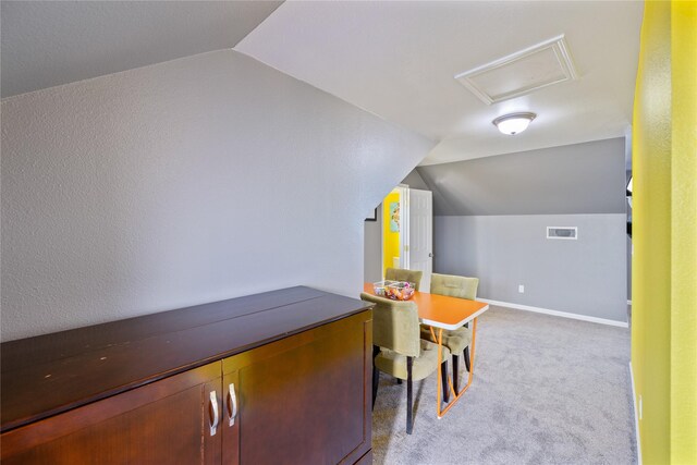 interior space with light colored carpet and lofted ceiling