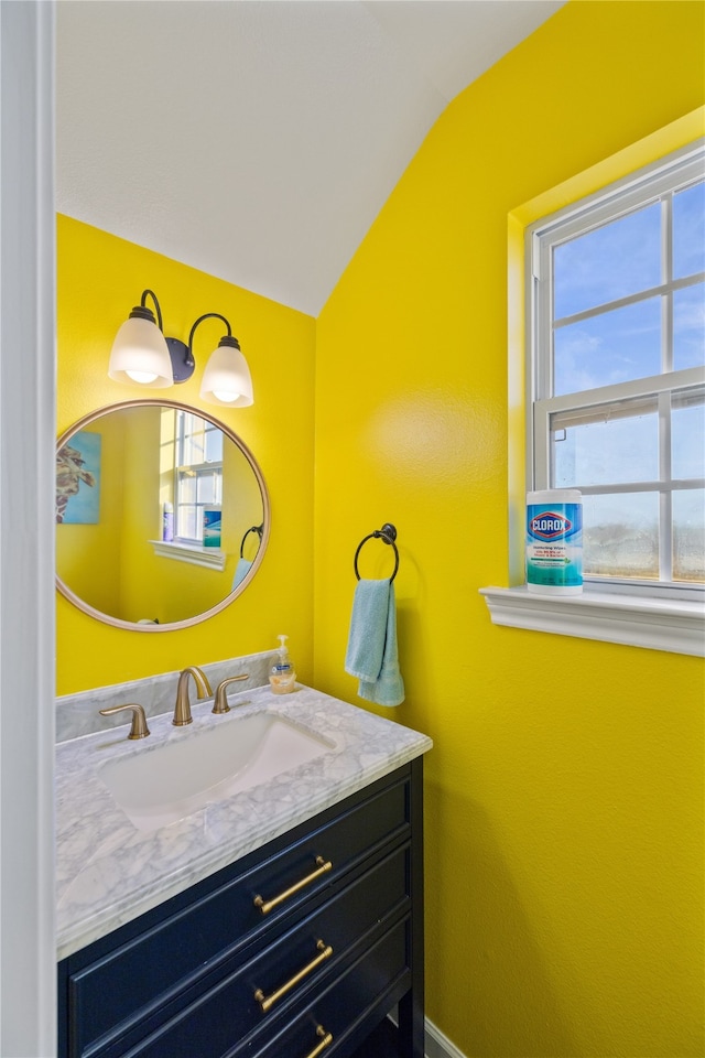 bathroom with vanity and lofted ceiling