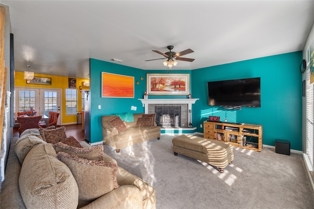 carpeted living room featuring ceiling fan and a fireplace