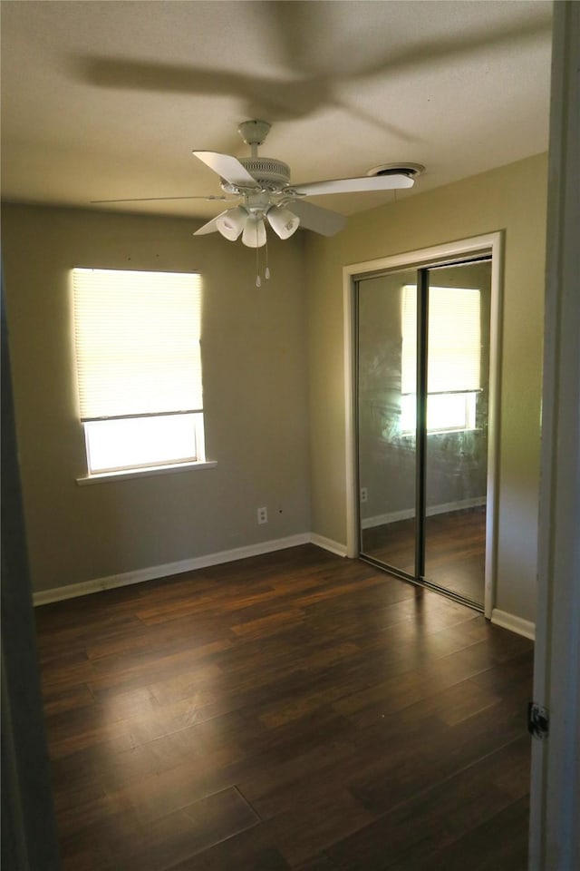 empty room with ceiling fan and dark hardwood / wood-style floors