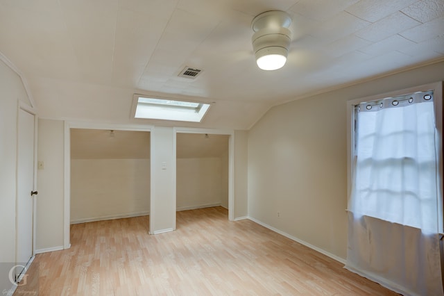 bonus room featuring light hardwood / wood-style floors and lofted ceiling with skylight