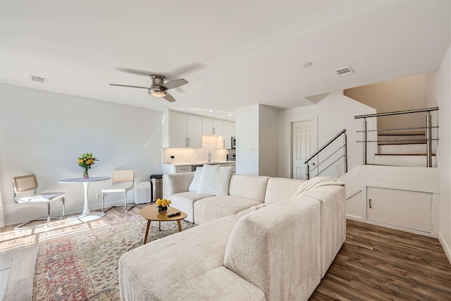 living room with ceiling fan, dark hardwood / wood-style flooring, and sink