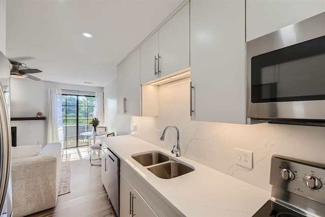 kitchen featuring white cabinetry, sink, light hardwood / wood-style floors, and appliances with stainless steel finishes