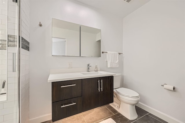 bathroom with tile patterned floors, a shower with door, vanity, and toilet