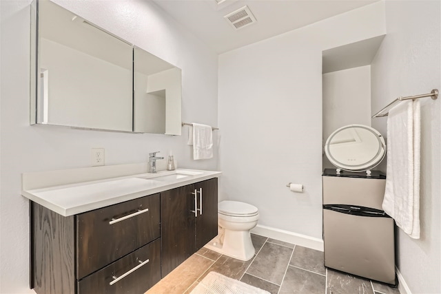 bathroom featuring tile patterned floors, vanity, and toilet