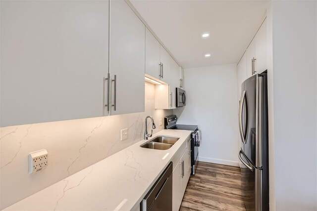 kitchen with white cabinetry, sink, dark wood-type flooring, decorative backsplash, and appliances with stainless steel finishes