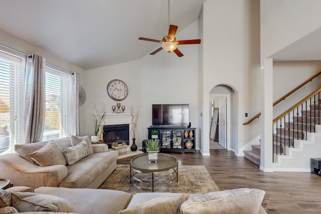 living room featuring ceiling fan, high vaulted ceiling, and wood-type flooring