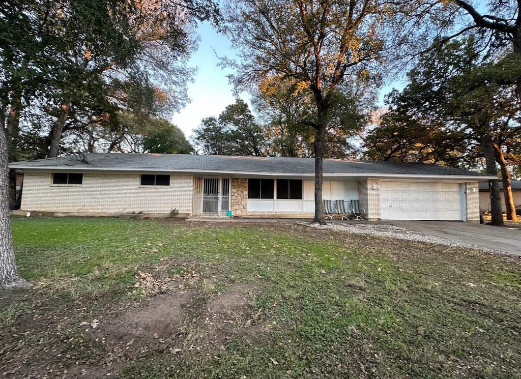 single story home featuring a front yard and a garage