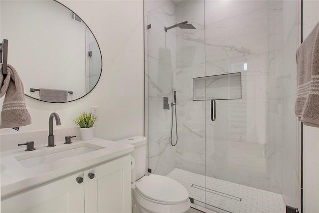 bathroom featuring vanity, toilet, and a shower with door