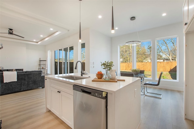 kitchen featuring dishwasher, sink, pendant lighting, a center island with sink, and white cabinets