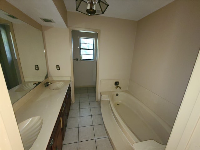 bathroom featuring a bathing tub, tile patterned flooring, vanity, and a chandelier