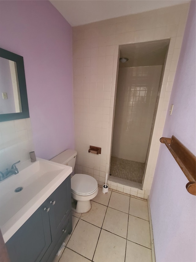 bathroom with a tile shower, tile patterned floors, vanity, and toilet