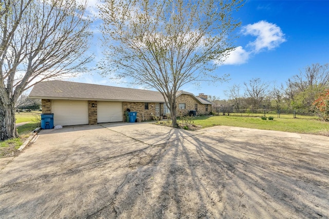 ranch-style home featuring a garage and a front lawn