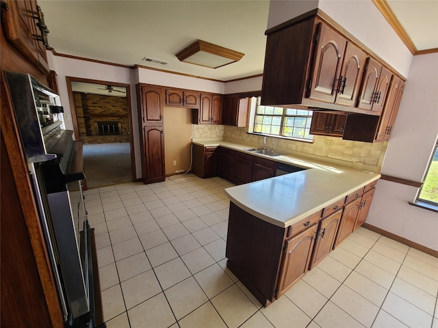 kitchen featuring kitchen peninsula, a fireplace, refrigerator, and a healthy amount of sunlight