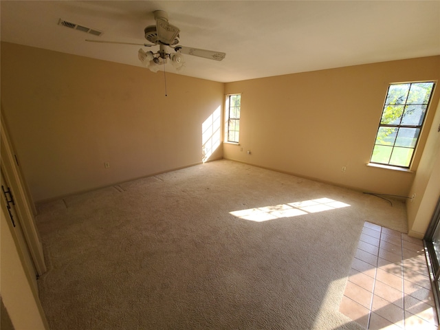 carpeted spare room with ceiling fan