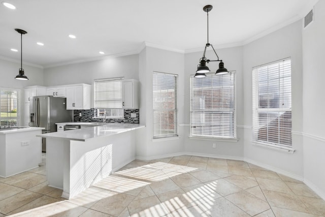 kitchen with a breakfast bar area, white cabinetry, crown molding, pendant lighting, and decorative backsplash