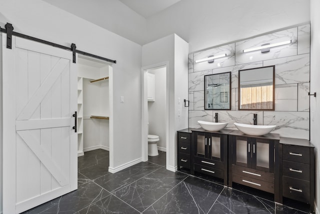 bathroom with a tile shower, vanity, and toilet