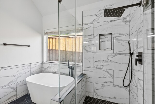 bathroom featuring tile walls and shower with separate bathtub