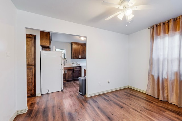 empty room with dark hardwood / wood-style floors, ceiling fan, and sink