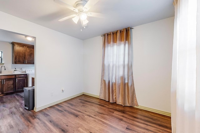 spare room featuring ceiling fan, plenty of natural light, dark wood-type flooring, and washer / clothes dryer