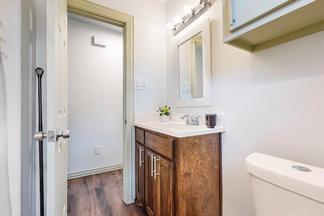 bathroom with vanity, toilet, and wood-type flooring