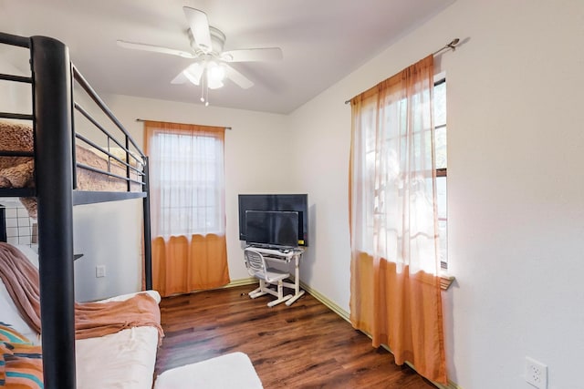 living area featuring ceiling fan, a healthy amount of sunlight, and dark wood-type flooring