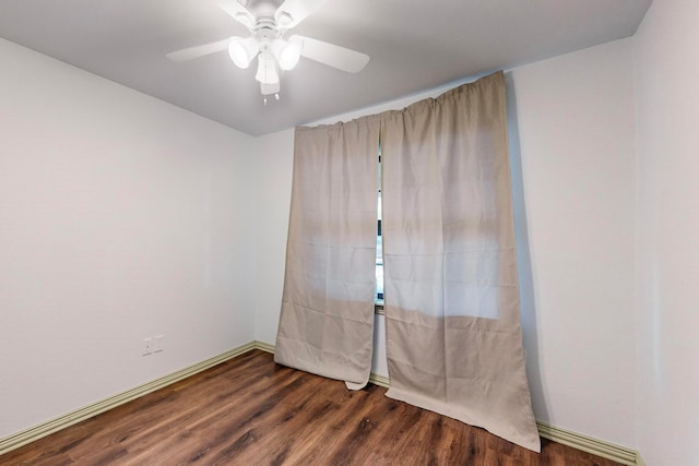 spare room with dark hardwood / wood-style flooring and ceiling fan