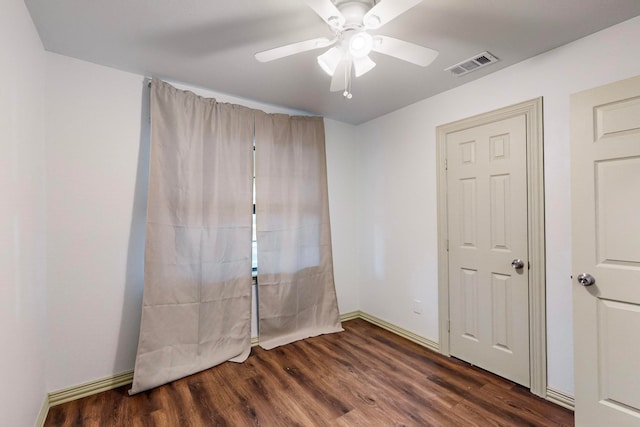 empty room featuring ceiling fan and dark hardwood / wood-style flooring