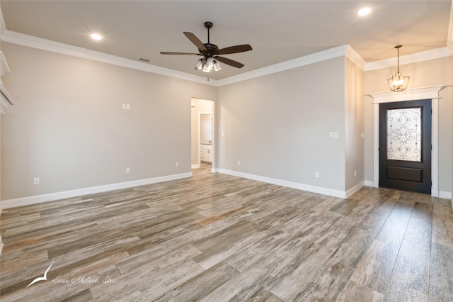 entrance foyer featuring ceiling fan with notable chandelier, wood-type flooring, and ornamental molding