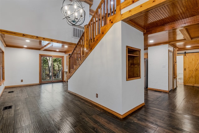 unfurnished living room featuring beam ceiling, wooden ceiling, a barn door, dark hardwood / wood-style flooring, and a chandelier