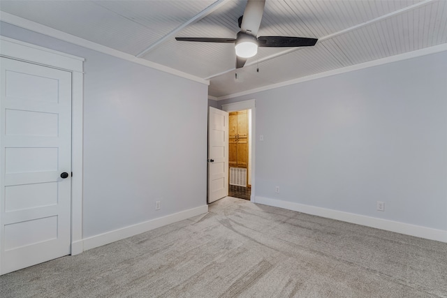 empty room with ceiling fan, crown molding, and light carpet