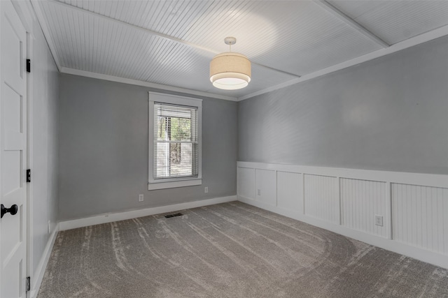 carpeted spare room featuring crown molding