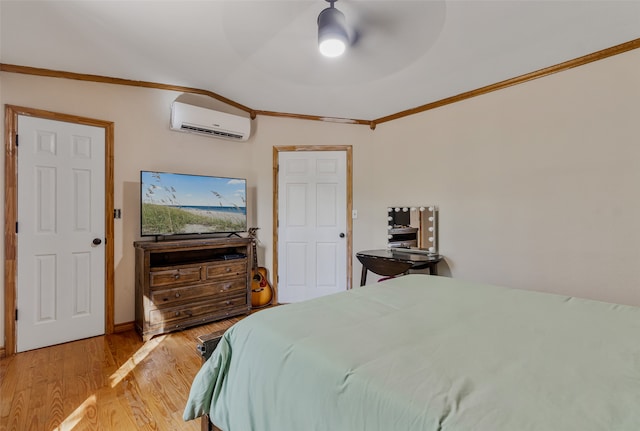 bedroom with lofted ceiling, ceiling fan, light wood-type flooring, ornamental molding, and a wall unit AC