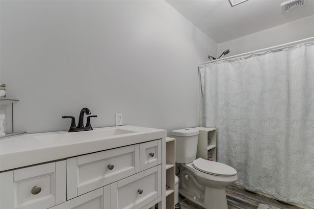 bathroom featuring curtained shower, vanity, wood-type flooring, and toilet