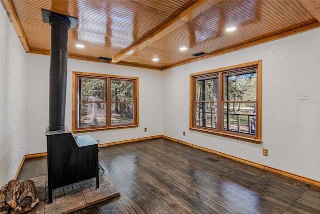 unfurnished room with a wood stove, wooden ceiling, beamed ceiling, and wood-type flooring