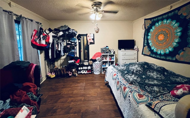 bedroom with a textured ceiling, crown molding, ceiling fan, and dark hardwood / wood-style floors