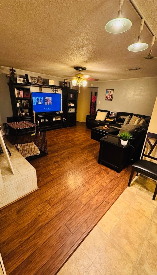 living room with ceiling fan, hardwood / wood-style floors, and a textured ceiling