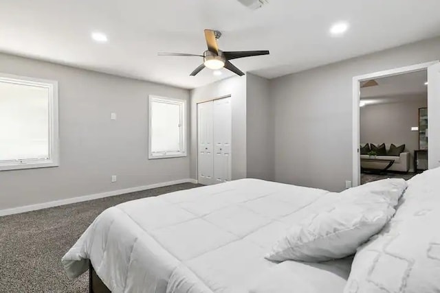 carpeted bedroom with ceiling fan, a closet, and multiple windows