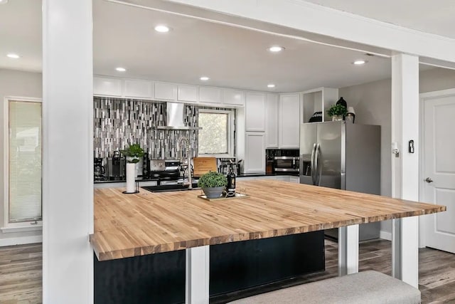 2030 Klondike St, Grand Prairie, TX 75050 - kitchen featuring wood counters, wood finished floors, decorative backsplash, white cabinets, and wall chimney exhaust hood