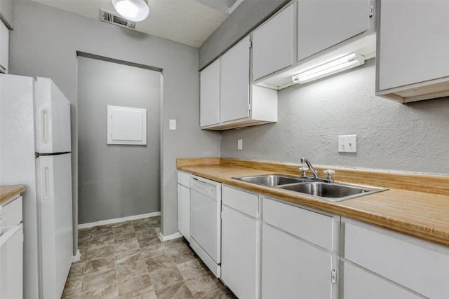 kitchen with white appliances, white cabinetry, and sink