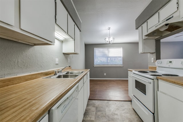 kitchen with light wood-type flooring, white appliances, sink, white cabinets, and hanging light fixtures