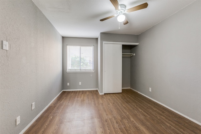 unfurnished bedroom featuring dark hardwood / wood-style flooring, a closet, and ceiling fan