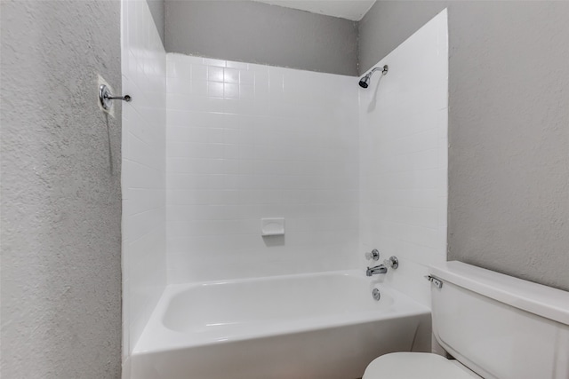 bathroom with tiled shower / bath combo and toilet