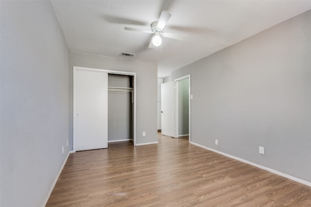 unfurnished bedroom with light wood-type flooring, a closet, and ceiling fan