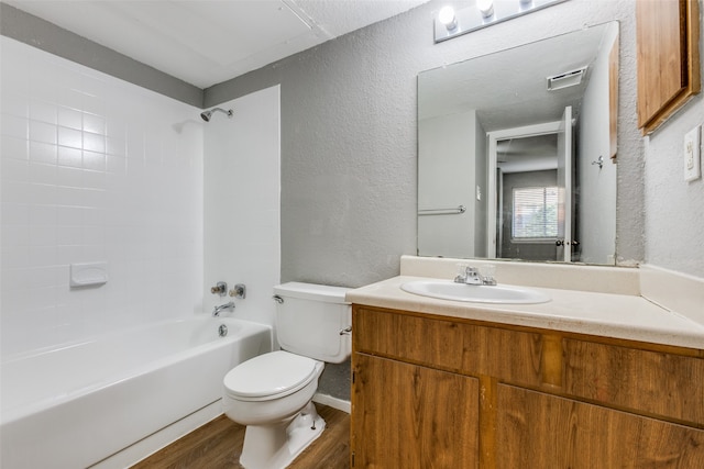 full bathroom with vanity, wood-type flooring, tiled shower / bath combo, and toilet