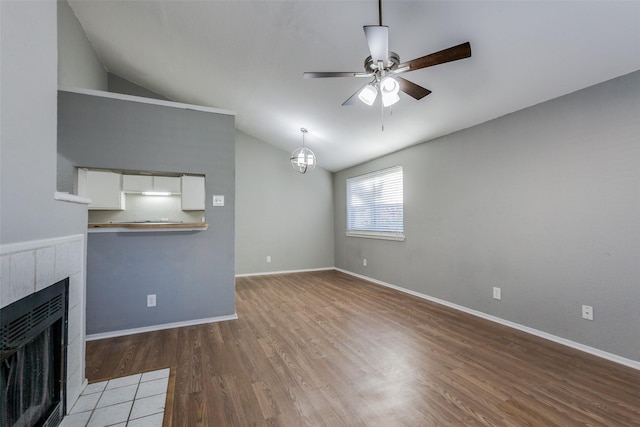 2240 Tarpley Rd Unit 462, Carrollton, TX 75006 - unfurnished living room featuring vaulted ceiling, a ceiling fan, a fireplace, and wood finished floors