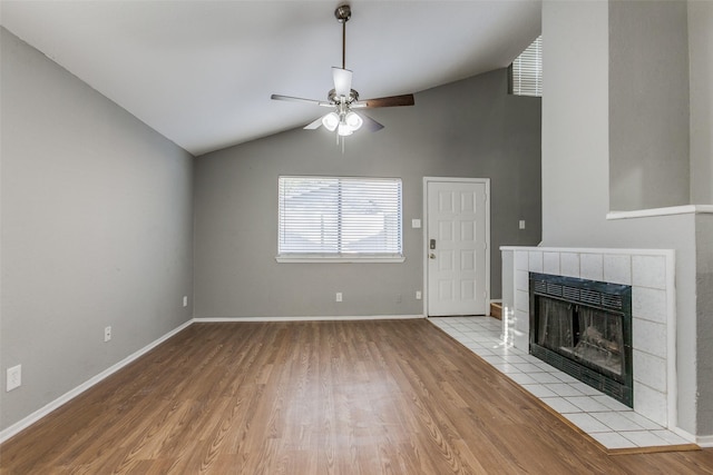 2240 Tarpley Rd Unit 462, Carrollton, TX 75006 - unfurnished living room with vaulted ceiling, ceiling fan, light wood finished floors, and a tiled fireplace